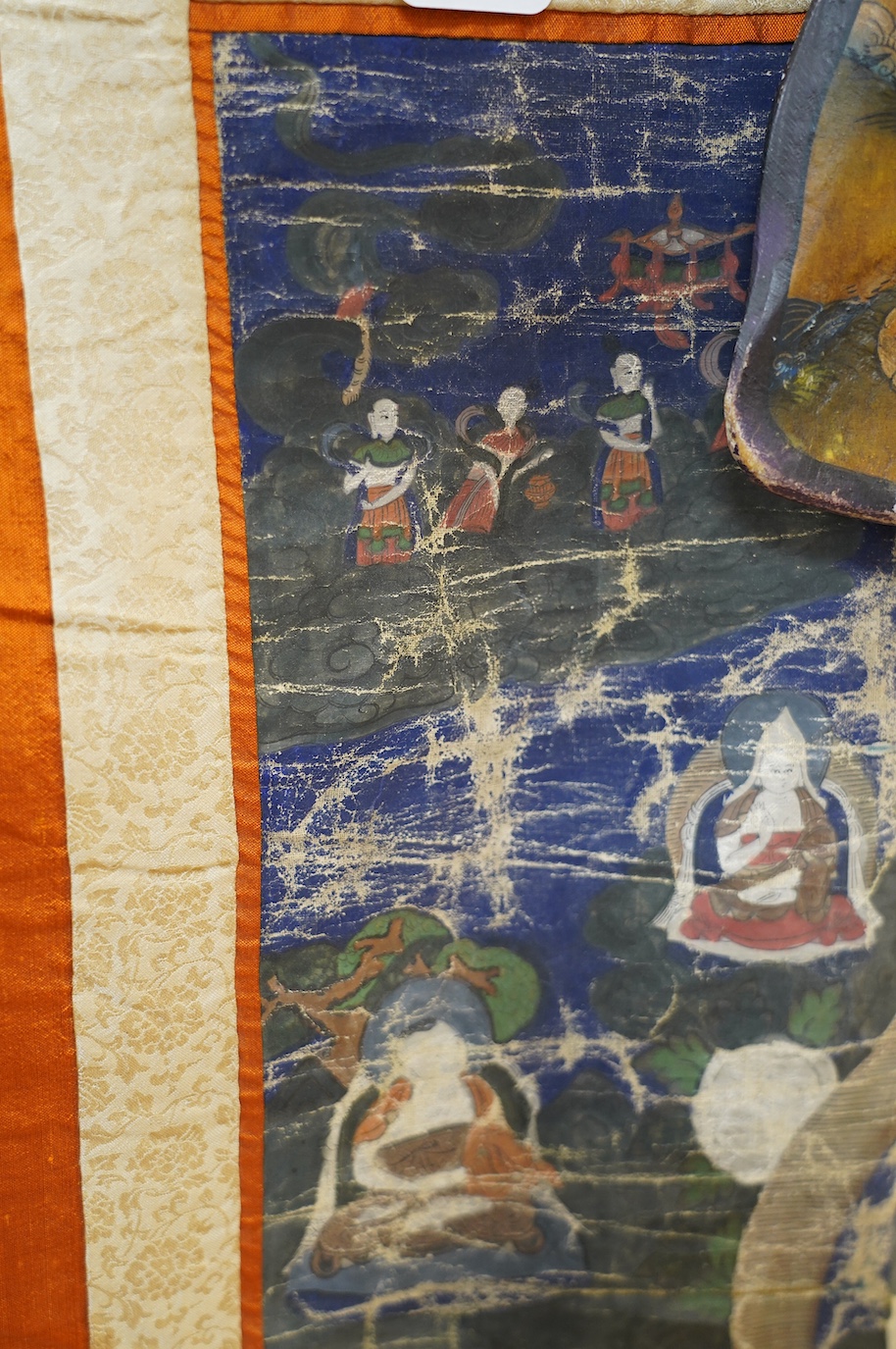 A Tibetan painted silk thangka and another painted on an ox bone, both 19th century. Condition - poor to fair